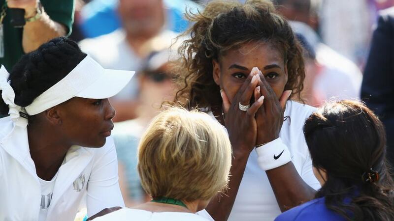 Serena Williams receives treatment during the warm-up before her second-round doubles match with her sister Venus Williams against Kristina Barrois and Stefanie Voegele. She later had to concede the match after suffering an unspecified illness. Photograph: Photograph: Jan Kruger/Getty Images