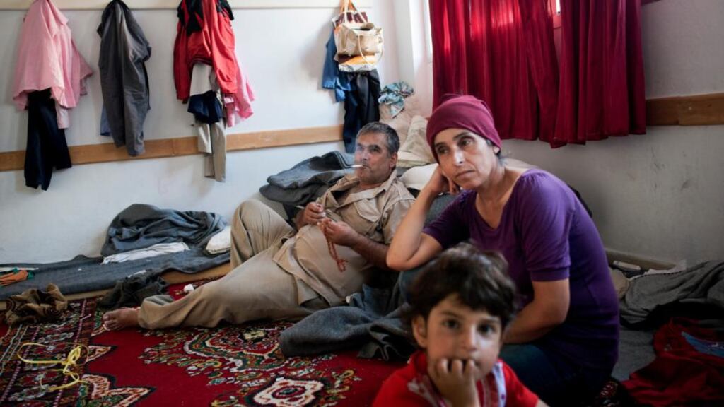 A family at a state-run shelter where the Syrian government placed surviving families of a reported rebel massacre in Latakia. Photograph: Andrea Bruce/The New York Times