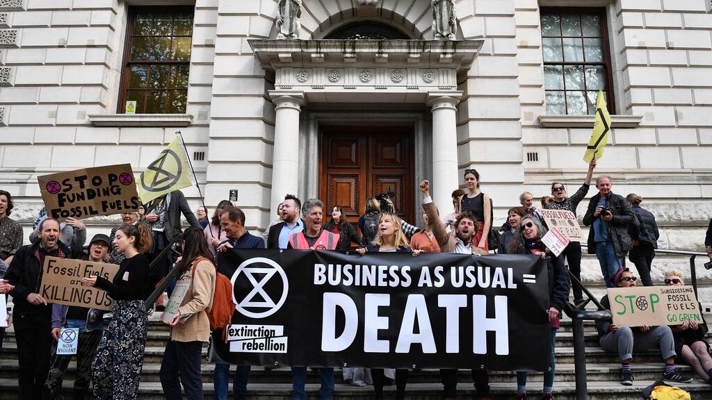 Climate change activists stage a protest outside the HM Treasury building in central London, during environmental protests by the Extinction Rebellion group. Photograph: Daniel Leal-Olivas/AFP