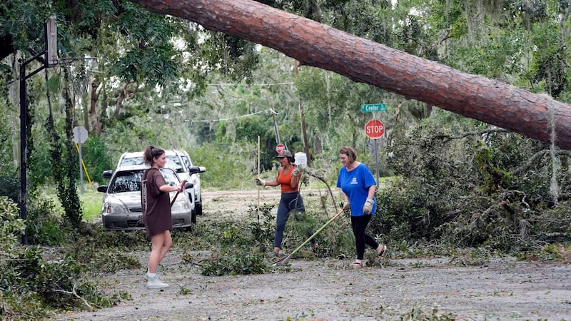 Alana Hall, Kayci Carter, and Tracy Hall clean up debris caused by Hurricane Idalia in front of their home in Perry, Florida. Photograph: John Raoux/AP