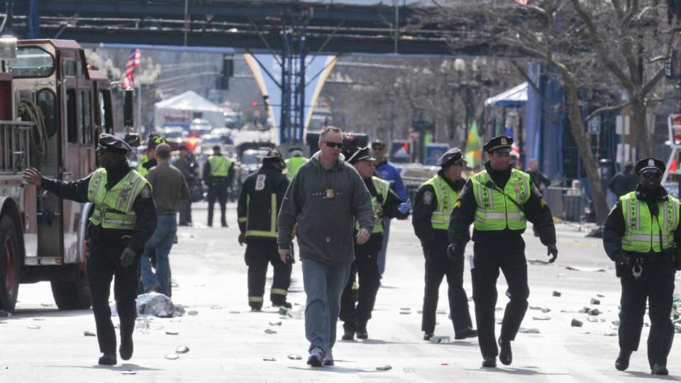 Public safety officials evacuate the scene after several explosions near the finish line of the 117th Boston Marathon in Boston. Photograph: Neal Hamberg/Reuters