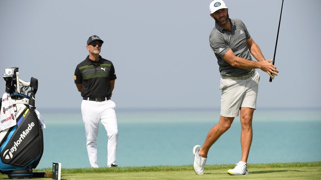 Dustin Johnson watched by his coach Claude Harmon III during the pro-am event prior to the Saudi International at Royal Greens Golf and Country Club in King Abdullah Economic City, Saudi Arabia. Photo: Ross Kinnaird/Getty Images