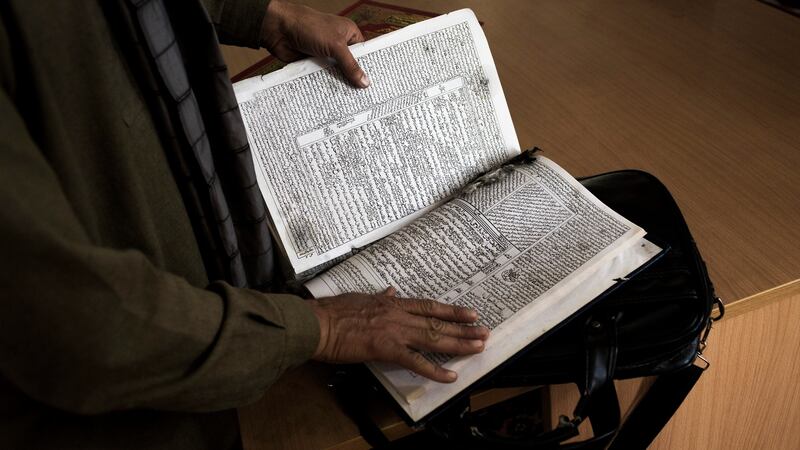 The ripped and blood-stained book that was in front of Mawlawi Shah Agha Hanafi, a revered religious scholar, when he was killed by the Taliban, in Togh-Bairdi, Afghanistan. Photograph: Jim Huylebroek/The New York Times