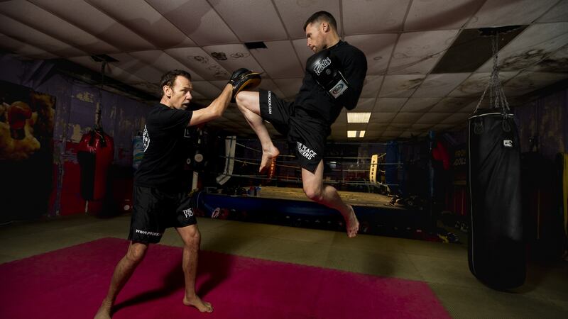 Billy Murray holds the pads as amateur world kick-boxing champion Johnny Smith strikes a flying knee during a sparring session at Prokick Gym in Belfast. Photograph: Liam McBurney