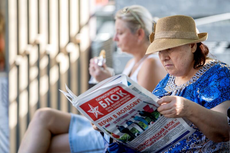 A woman reads an electoral newspaper in Chisinau, Moldova. Photograph: EPA