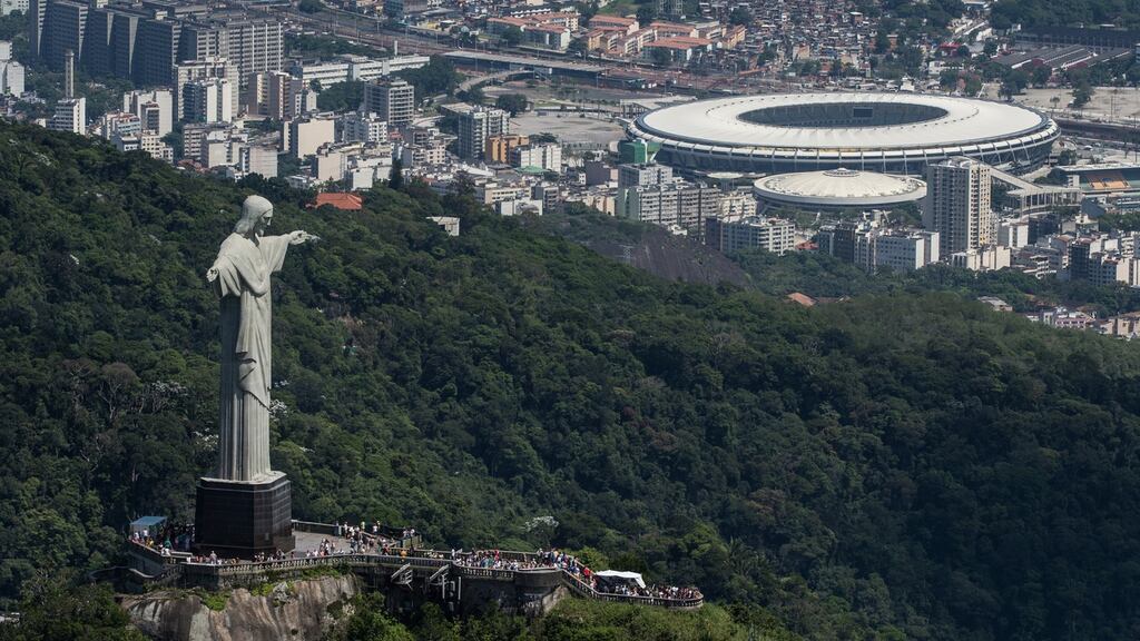 Aerial view of the Christ the Redeemer statue atop Corcovado Hill and the Mario Filho (Maracana) stadium in Rio de Janeiro, Brazil, on December 3, 2013. The Maracana stadium will host the Brazil 2014 FIFA World Cup and the 2016 Summer Olympics. AFP PHOTO / YASUYOSHI CHIBA JAPAN OUT (Photo credit should read YASUYOSHI CHIBA/AFP/Getty Images)