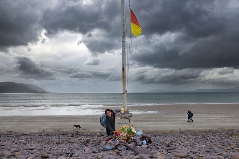 Angela O'Flaherty, leaves flowers at a memorial site of flowers and tributes for the late Jack de Bromhead, at Rossbeigh Strand in Co Kerry. Photo: Valerie O'Sullivan