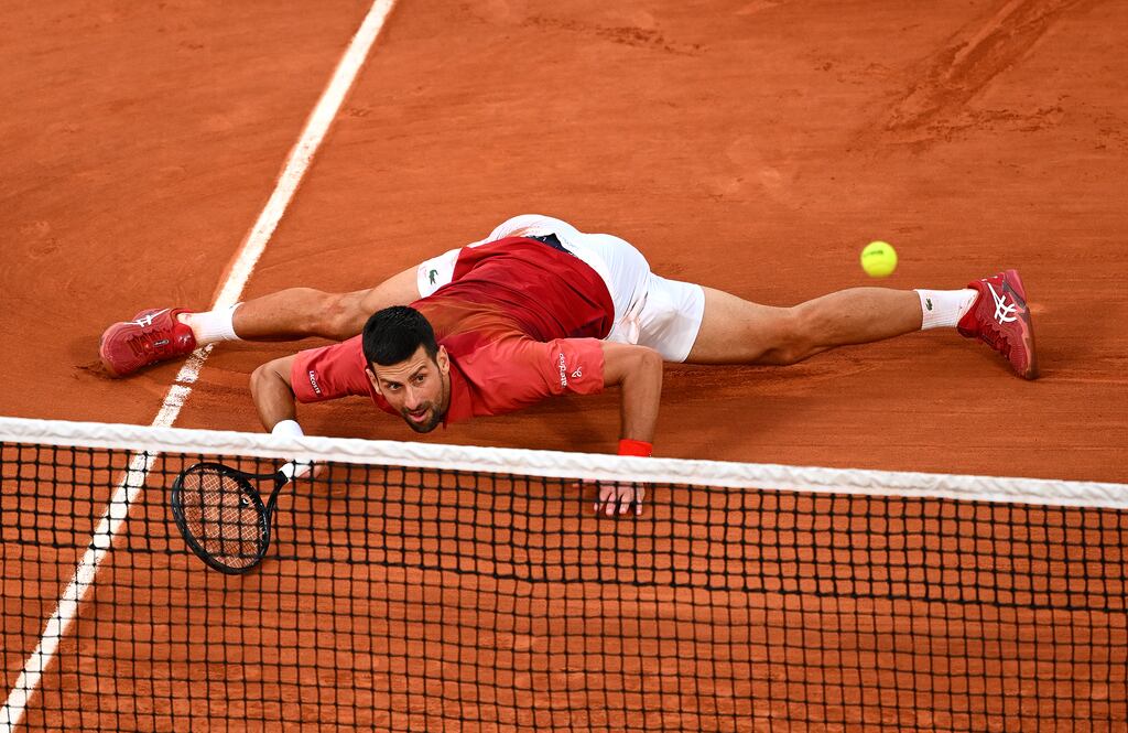 Novak Djokovic of Serbia slides at the net for a forehand against Francisco Cerundolo. Photograph: Clive Mason/Getty