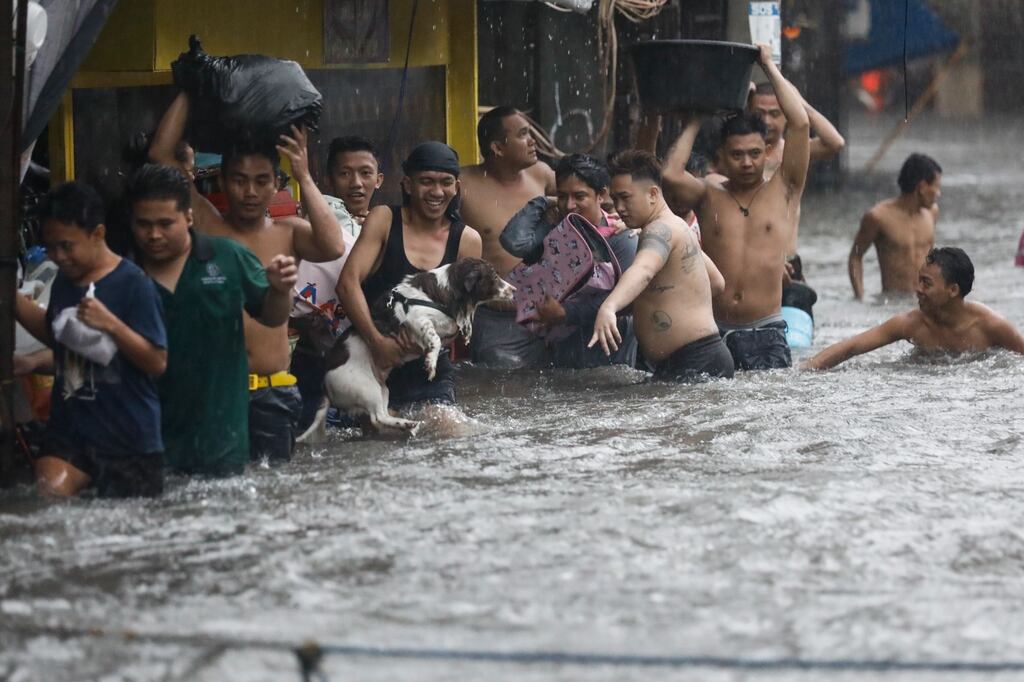 Residents walk in floodwater in Quezon City, Metro Manila, Philippines, 24 July 2024.