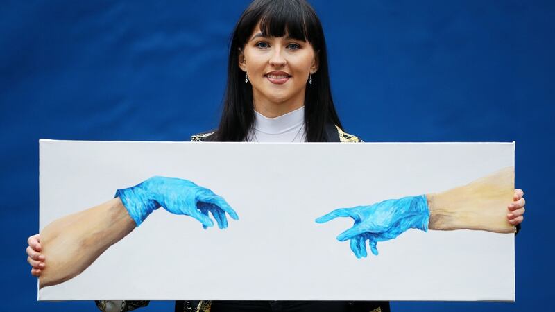 Chloe Slevin with her painting The Separation of Adam, a reinterpretation of Michelangelo’s masterpiece to tell the story of the pandemic. Photograph: Brian Lawless/PA
