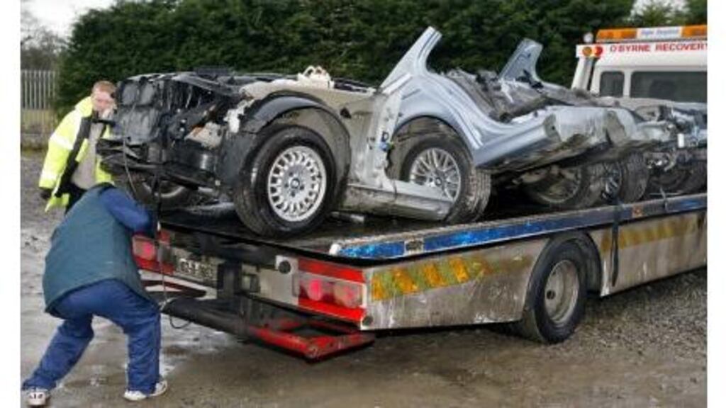 Car parts are loaded for transportation to the Garda technical bureau at the scene where gardai discovered stolen cars in Co Kildare