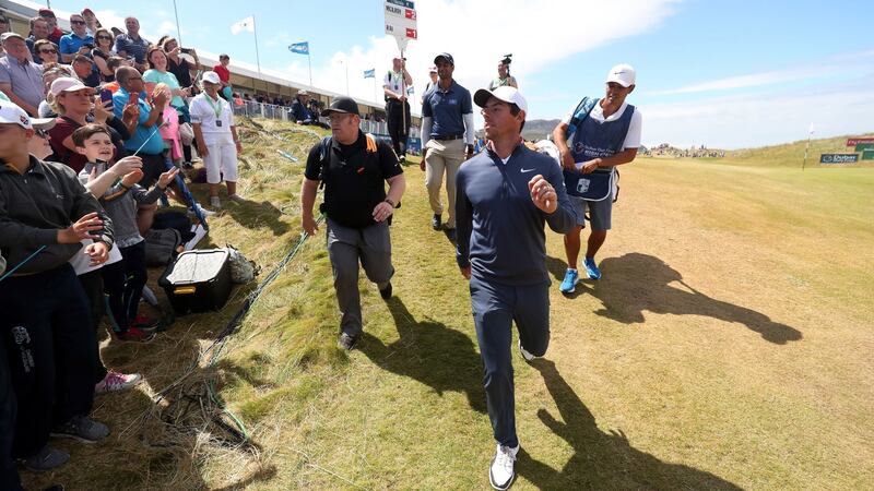 Rory McIlroy throws a ball to the crowd as he leaves the 18th green. Photo: Niall Carson/PA Wire