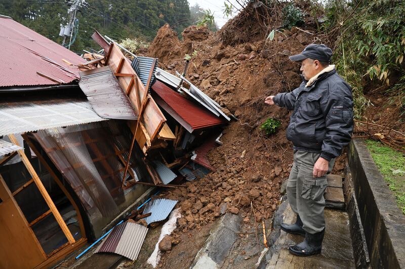 A man looks at his home crushed by a landslide in the town of Anamizu, Ishikawa prefecture, on Wednesday, in the aftermath of the earthquake on New Year's Day. Photograph: STR/Jiji Press/AFP via Getty Images
