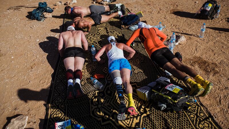 Amy Palmiero-Winters, centre, does push-ups with fellow runners before day one of the Marathon des Sables.