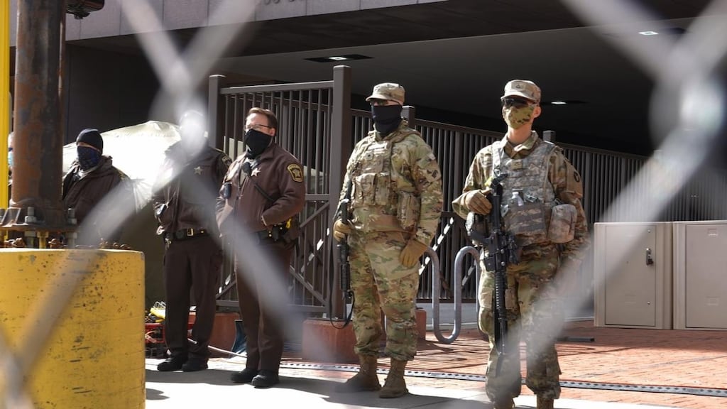 Police and National Guard troops stand watch outside of the Hennepin County Government Center while activists march past on March 28, 2021 in Minneapolis, Minnesota. The activists were demonstrating before the start of trial of former Minneapolis police officer Derek Chauvin, who is accused of murder in the death of George Floyd. Photograph: Getty Images