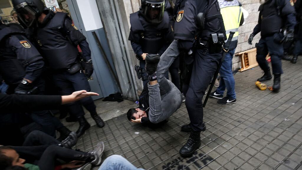 Spanish police officers drag a man as they try to disperse voters arriving to a polling station in Barcelona on October 1st. Photograph: Pau Barrena/AFP/Getty