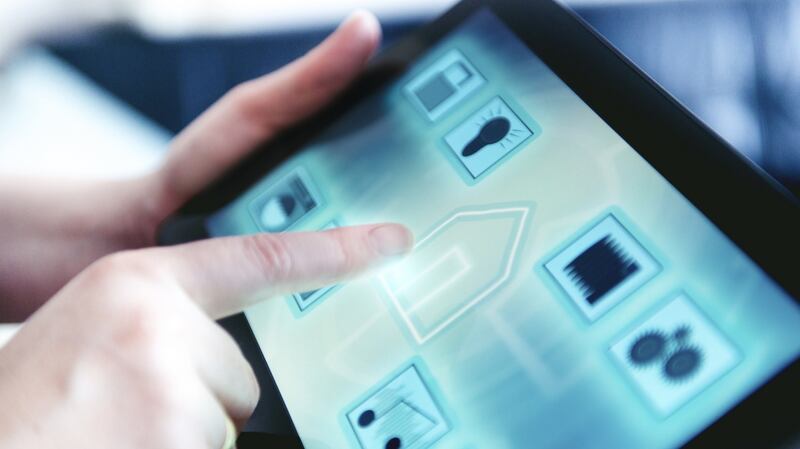 Tablet with an app controls several features in the home such as door lock, lights, washing machine, surveillance camera, music, water use and more. Woman press the tablet, that shows a icon of a house.