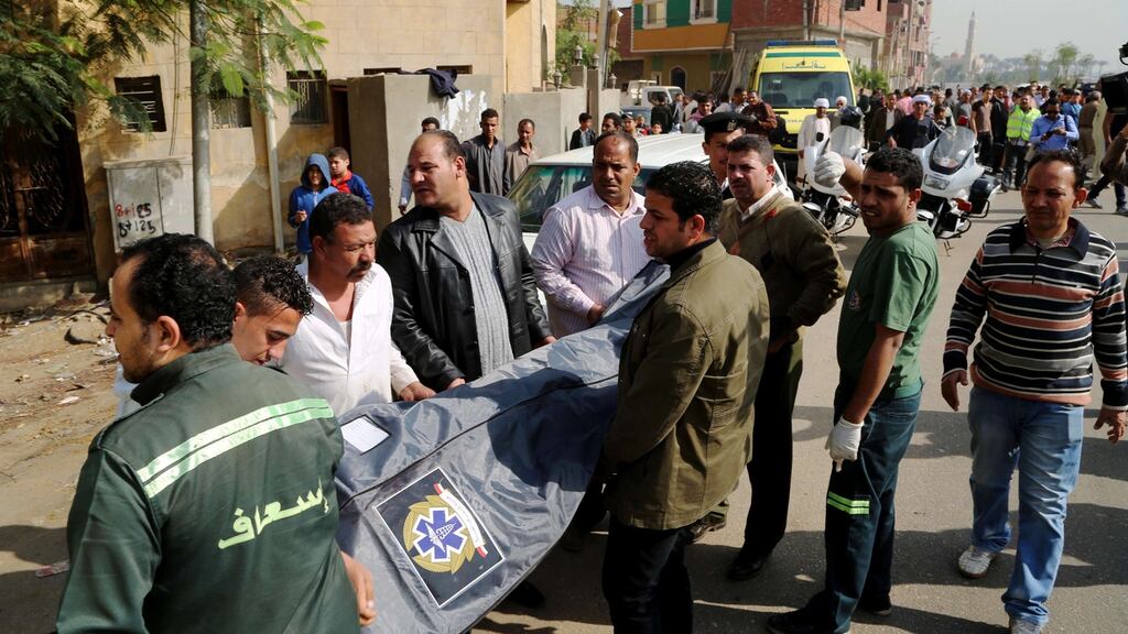 Emergency personnel carry a body at the site where masked gunmen on a motorcycle shot dead four Egyptian policemen south of the capital Cairo. Photograph: AFP/Getty Images