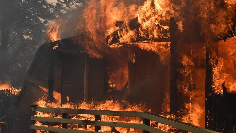 Fire burns a home in Buxton, New South Wales. Photograph: EPA
