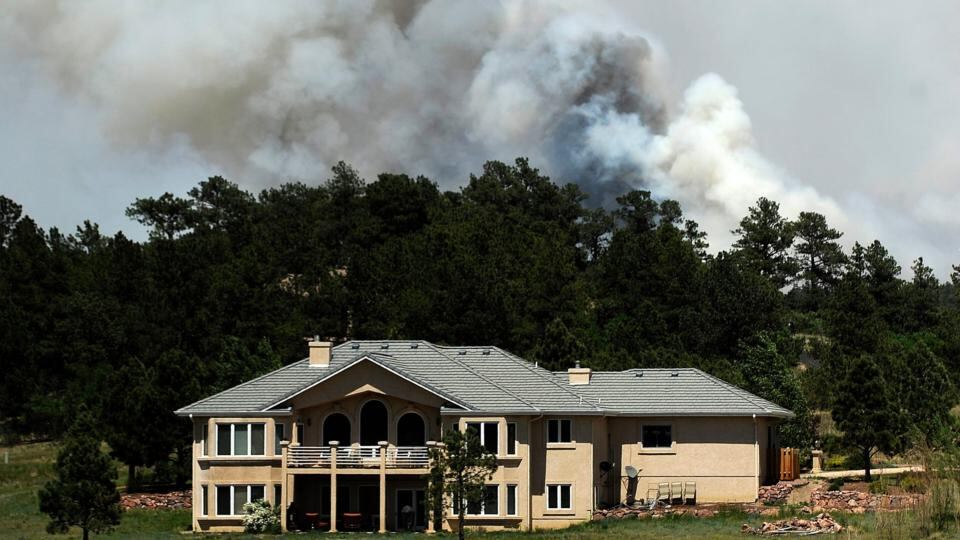 Smoke billows near a home from the Black Forest Fire  north of Colorado Springs, Colorado. Photograph:  Chris Schneider/Getty Images