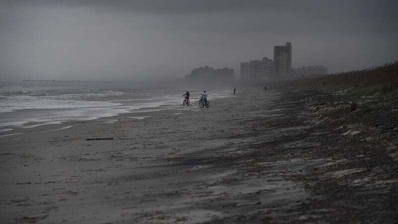 People bike on the beach ahead of hurricane Matthew in Atlantic Beach, Florida. Photograph: AFP/Getty Images