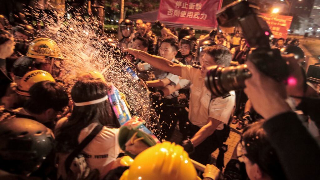 A police officer uses pepper spray on demonstrators during a protest outside the Central Government Offices in the Admiralty district of Hong Kong in November 2014. File photograph: Billy HC Kwok/Bloomberg