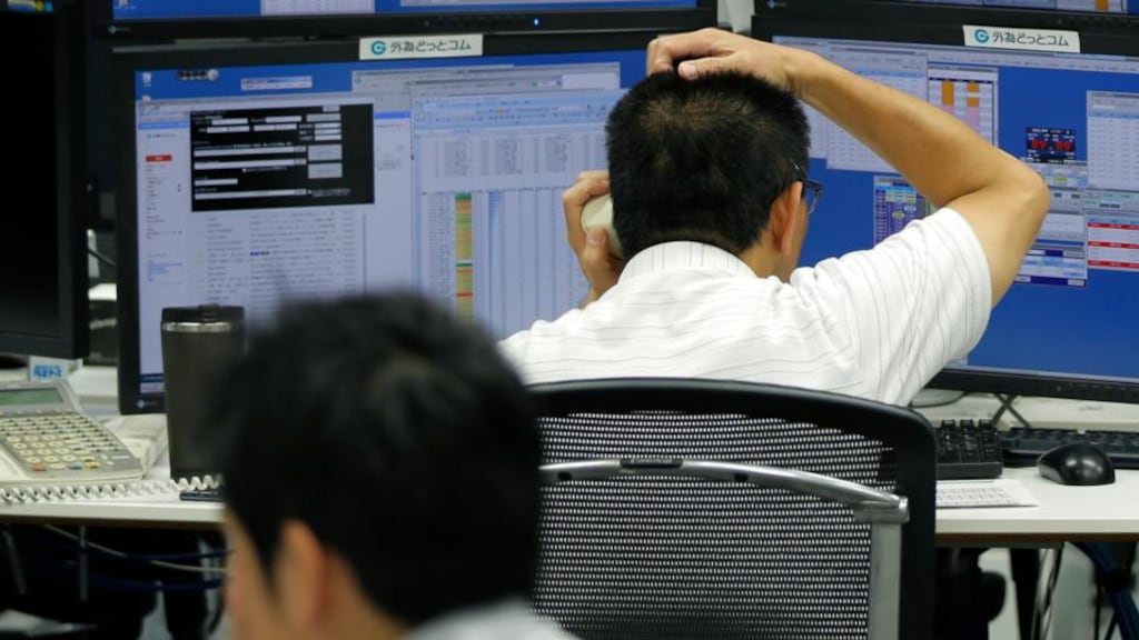 Employees work in front of computer screens at a foreign exchange brokerage in Tokyo, Japan. Photographer: Kiyoshi Ota/Bloomberg