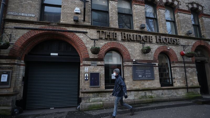 A mask-clad man walks past the closed Bridge House Pub in Belfast this week during Northern Ireland’s continued lockdown to curb coronavirus. File photograph: Liam McBurney/PA Wire