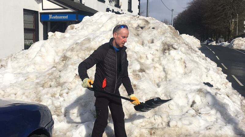 Michael Aherne of the Roundwood Inn shovels snow. Photograph: Tim O’Brien