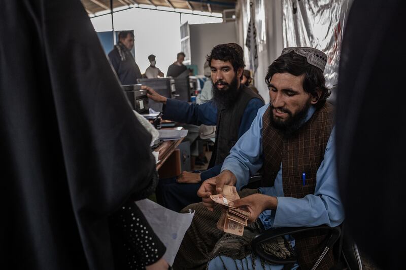 Taliban authorities distribute cash stipends to Afghans returning from Iran, many of whom were expelled with few belongings, at a reception centre in Islam Qala, Afghanistan. Photograph: Jim Huylebroek/The New York Times