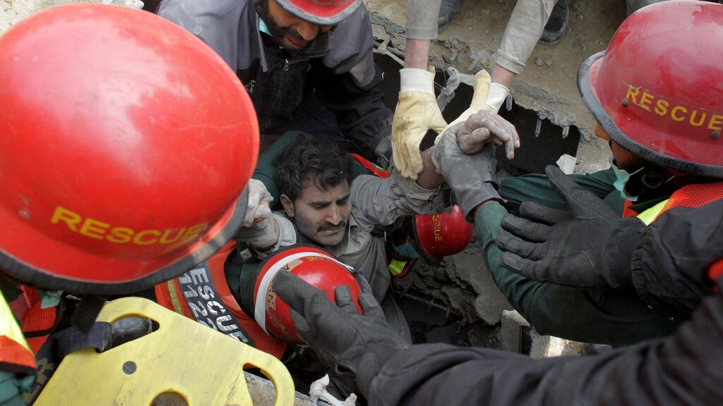 Volunteers rescue a man trapped in the rubble. No survivors have been recovered since Friday night. Photograph: KM Chaudary/AP Photo