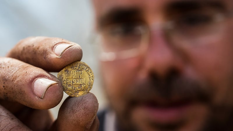 Israeli archaeologist Shahar Krispin displays an 1,100-year-old gold coin discovered at an archeological site in central Israel. Photograph: Heidi Levine/AP/Sipa Press
