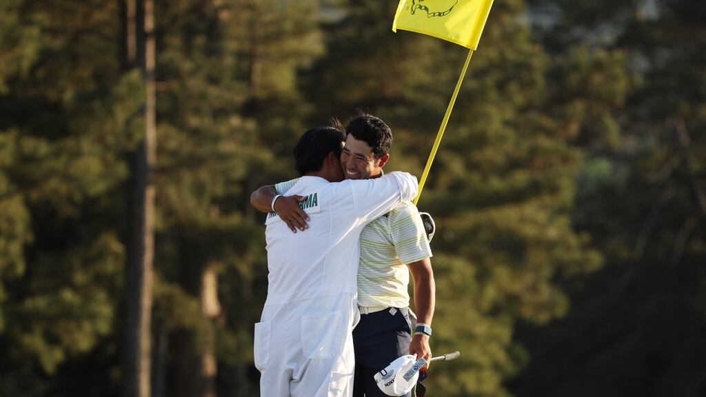 Hideki Matsuyama hugs his caddie Shota Hayafuji on the 18th green after winning the Masters at Augusta National Golf Club on Sunday. Photograph: Kevin C Cox/Getty Images