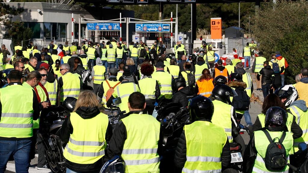 People wearing yellow vests, a symbol of a French drivers’ protest against higher fuel prices, block the toll both in Antibes, France. Photograph: Eric Gaillard/Reuters