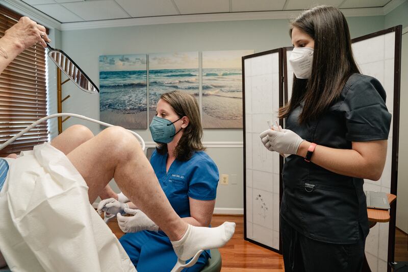 Dr Rubin with a patient at her clinic in Maryland. Rubin begins exams by handing the patient a mirror to see the same anatomy that she is examining. Photograph: Shuran Huang/The New York Times