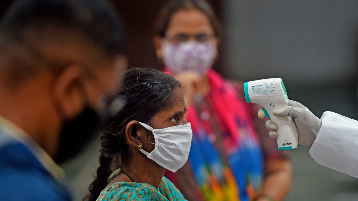 A medical volunteer takes a temperature reading of a woman at a marriage hall, which is temporarily converted into a Covid-19 testing centre, in Mumbai on Friday. Photograph: Punit Paranjpe/AFP/Getty Images