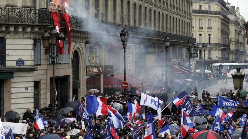 Femen activists (upper left) demonstrate on a balcony during a rally called by France’s far-right political party Front National (FN) in Paris. Photograph: Kenzo Tribouillard/AFP/Getty Images
