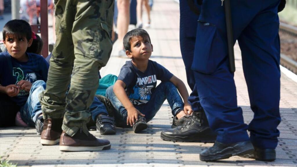 A boy looks at Hungarian police officers as a train heading for Austria, with migrants on board, is stopped for checks at a border station in Hegyeshalom, Hungary. Photograph: Heinz-Peter Bader/Reuters