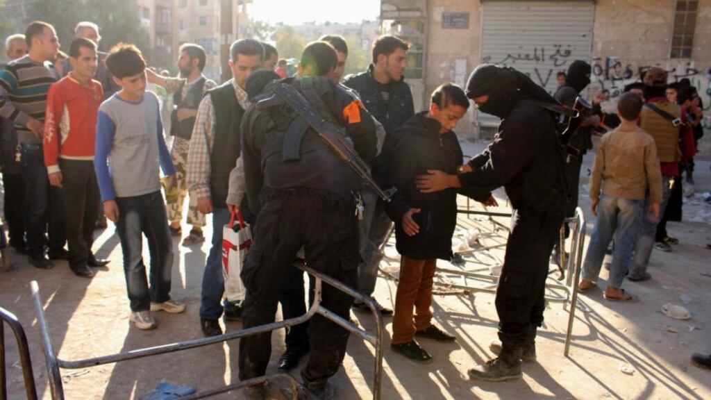 Fighters from the Islamist Syrian rebel group Jabhat al-Nusra search residents at a checkpoint in Aleppo’s Bustan al-Qasr. Photograph: Molhem Barakat/Reuters