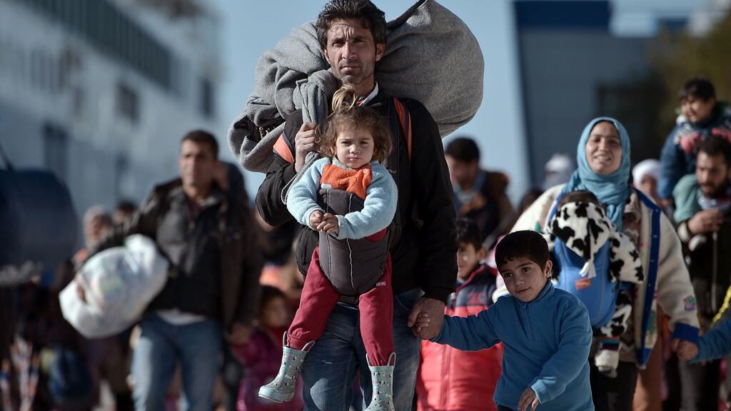 Migrants and refugees walking through the port of Piraeus after arriving from the Greek islands of Lesbos and Chios IN February, 2016: On Monday, some 460 people landed on Greek islands from Turkey – almost as many as arrived during the whole of the previous week and the biggest daily figure for several months. Photograph: Louisa Gouliamaki/AFP/Getty Images