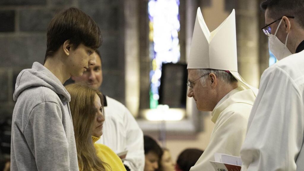 Bishop Michael Duignan extends a warm welcome to a Ukrainian family at Galway Cathedral. Photograph: Sean Feeney