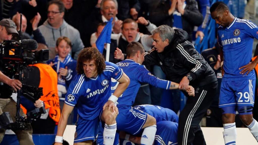 Chelsea’s Demba Ba (hidden) celebrates with coach Jose Mourinho and team mates after scoring the second goal for the team during their Champions League quarter-final second leg soccer match against Paris St Germain at Stamford Bridge. Photograph: Stefan Wermuth/Reuters