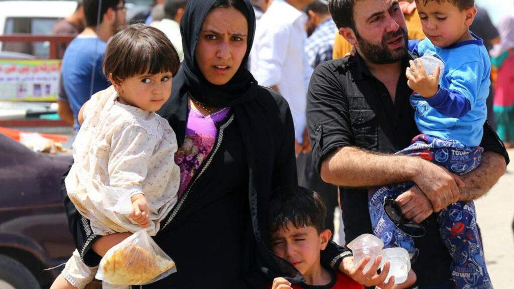 A family fleeing the violence in the Iraqi city of Mosul wait at a checkpoint in the outskirts of Arbil in Iraq’s Kurdistan region yesterday. Photograph: Reuters