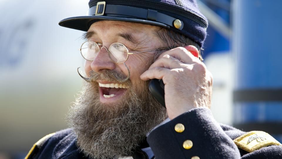 A Civil War reenactor in an officer’s uniform chats on his cell phone in the Union camp during the Battle of Gettysburg reenactment . Photograph: Melanie Stetson Freeman