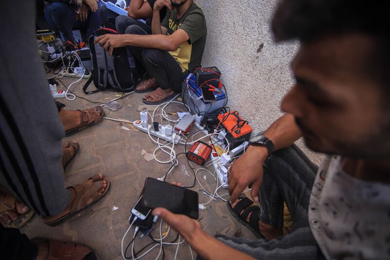 Palestinians charge mobile phones and batteries using portable charging stations in western Khan Younis. Photograph: Ahmad Salem/Bloomberg