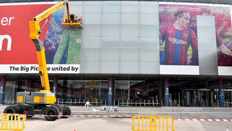 Workers remove a poster featuring Lionel Messi at the Camp Nou. Photograph: Pau Barrena/AFP via Getty Images