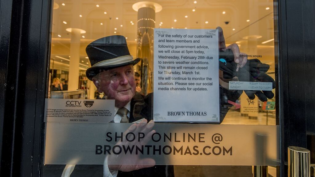 Jim Kearnes, consierge with Brown Thomas puts a sign up on their premises announcing its closure due to adverse weather.Photograph: Brenda Fitzsimons/The Irish Times
