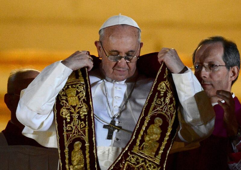 Pope Francis dons a stole, part of the liturgical vestment, after being elected by the conclave of cardinals. Photograph: Reuters