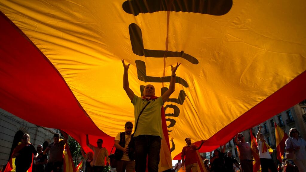 Protesters hold a giant Spanish flag during a demonstration called by “Societat Civil Catalana” (Catalan Civil Society) to support the unity of Spain on October 8, 2017 in Barcelona. JORGE GUERRERO/AFP/Getty Images