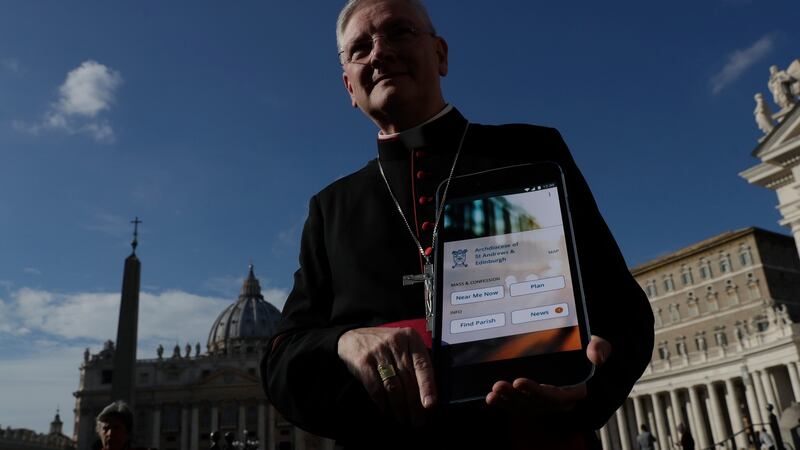 Archbishop Leo Cushley of St. Andrews and Edinburgh holds up a poster showing the new app. Photograph: Alessandra Tarantino/PA